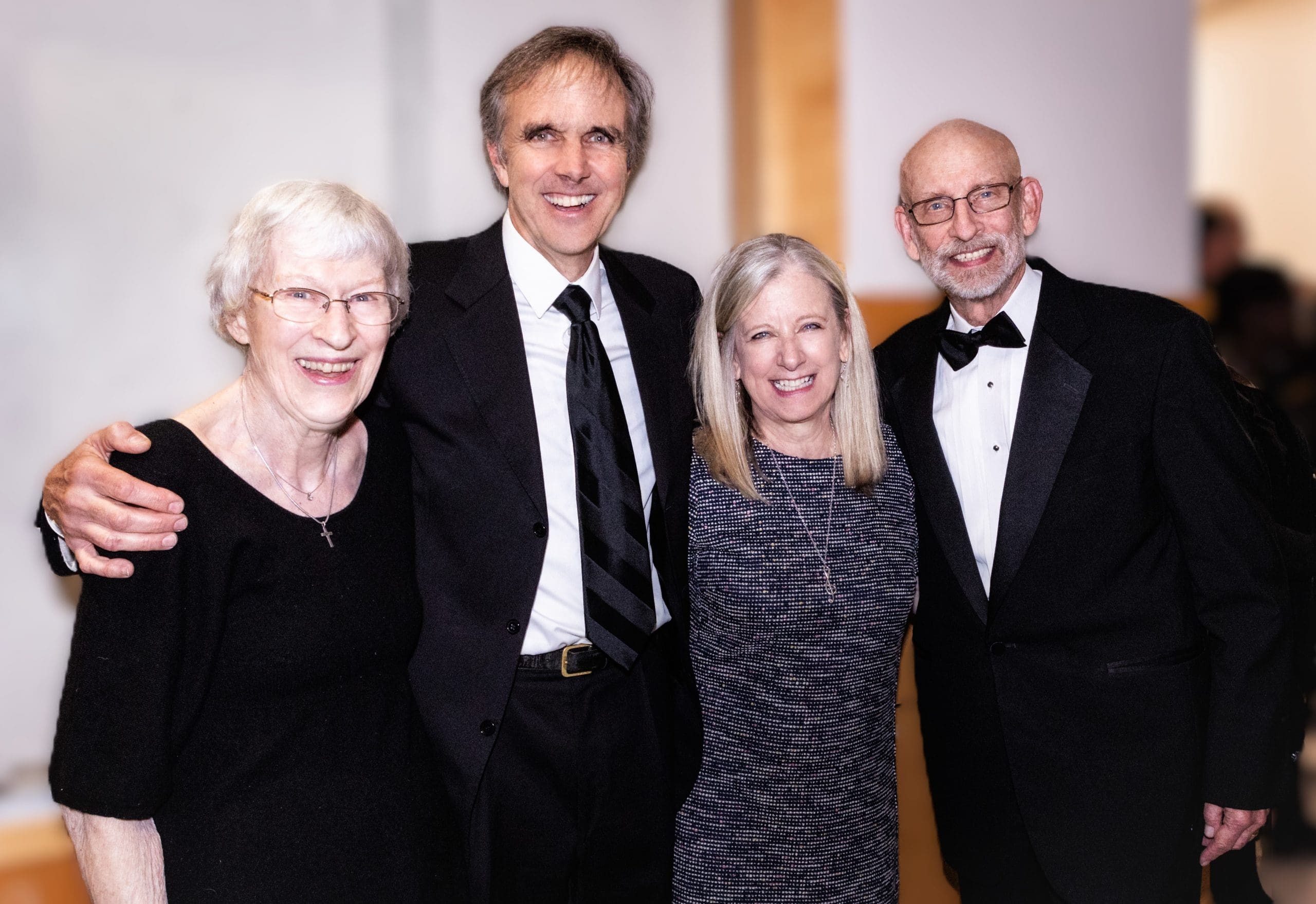 Group of 4 smiling well dressed 60 year olds.